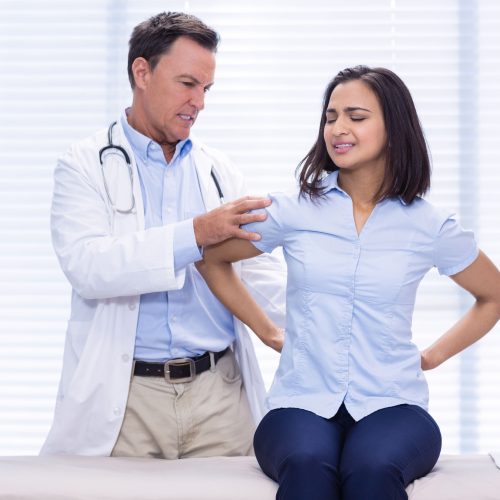 71311862 - female patient showing back pain to doctor in clinic