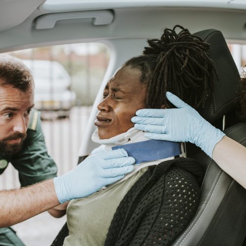 Paramedic placing a cervical collar to an injured woman from car accident Paramedic placing a cervical collar to an injured woman from car accident
